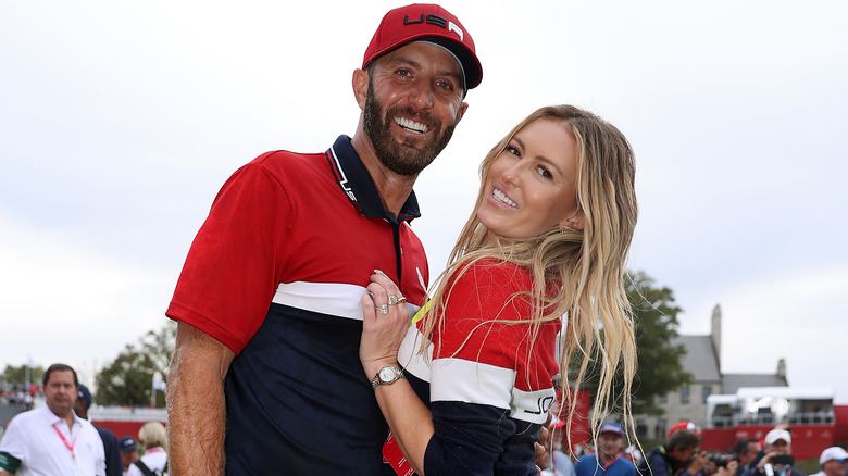 Paulina Gretzky and Dustin Johnson pose at a golf event