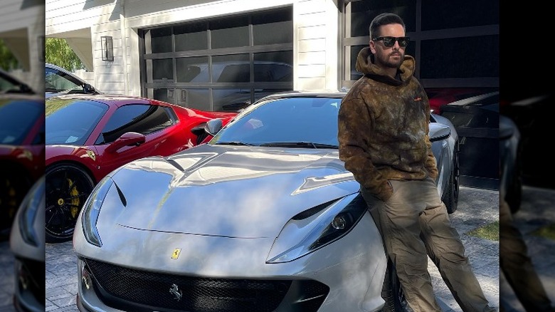 Scott Disick poses in front of car