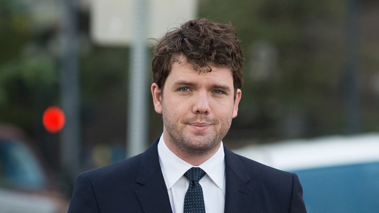 Austin Swift walking in the street in a suit