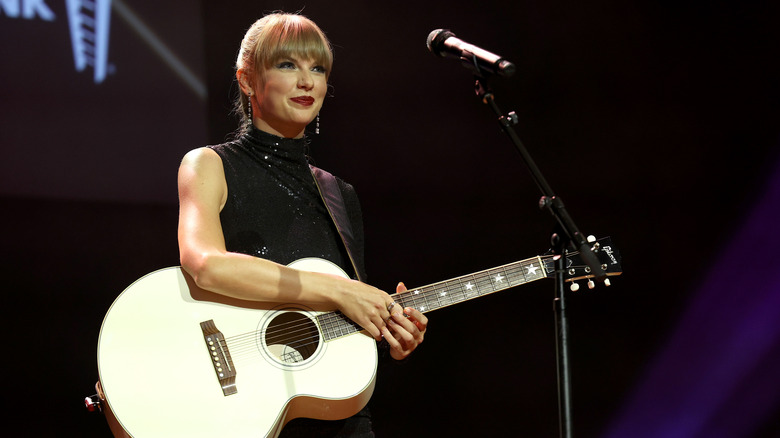 Taylor Swifts holds her guitar