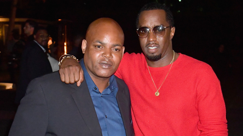 Sean Combs throwing an arm around Harve Pierre's shoulder