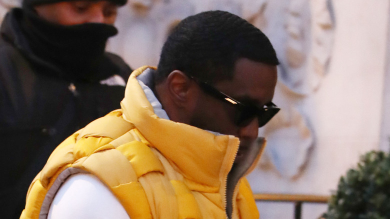 Diddy with his head down in a yellow vest