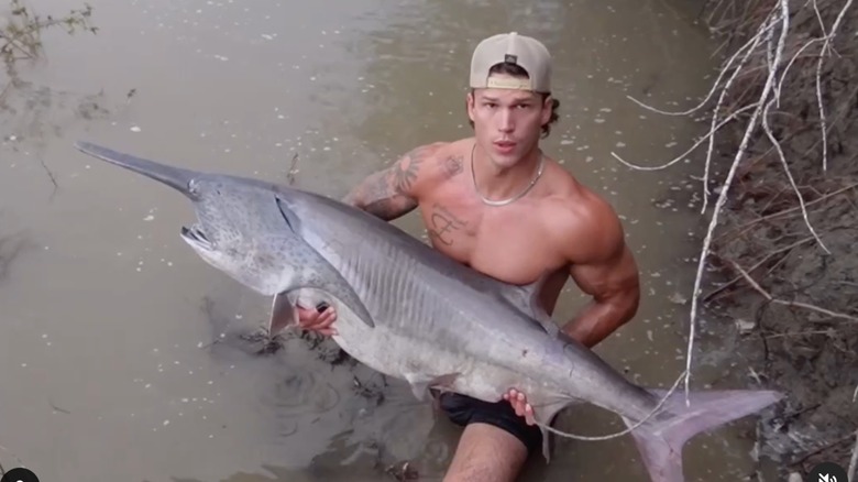 Mark Estes holding a giant fish in the water