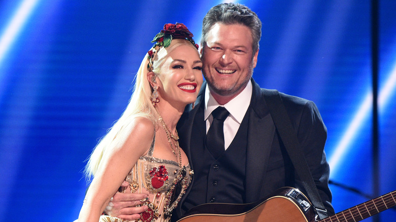 Gwen Stefani and Blake Shelton smiling on stage