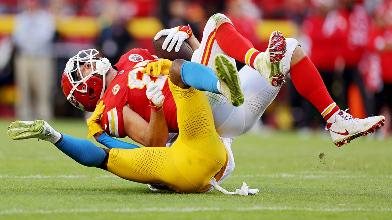 Travis Kelce getting tackled by Derwin James