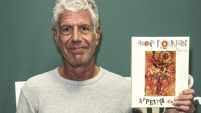 Anthony Bourdain shows off his book