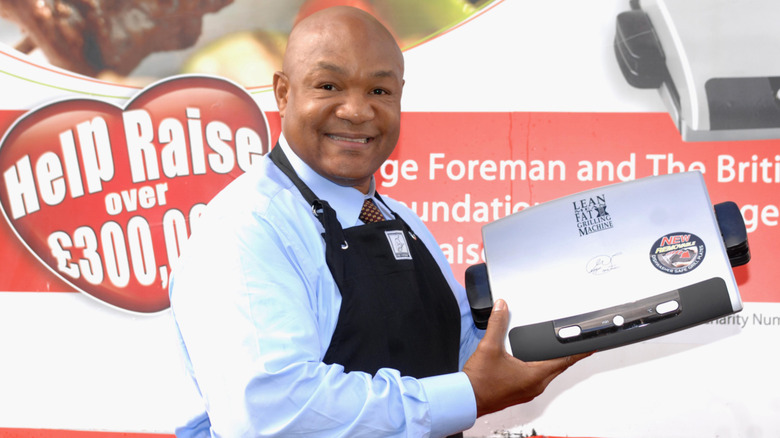 George Foreman holding up a George Foreman Grill