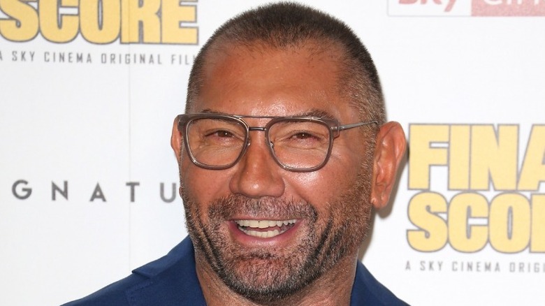 Dave Bautista laughing while on a red carpet
