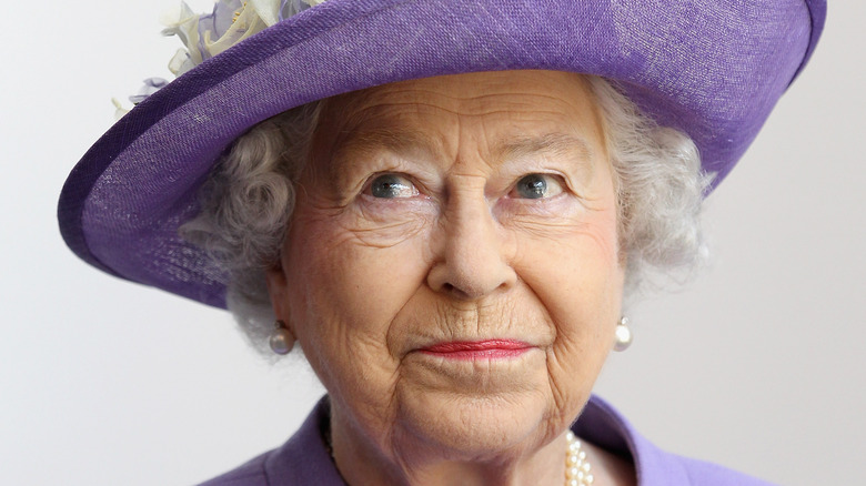 Queen Elizabeth II smiling purple hat