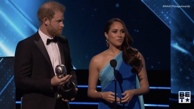 Prince Harry and Meghan Markle accepting award