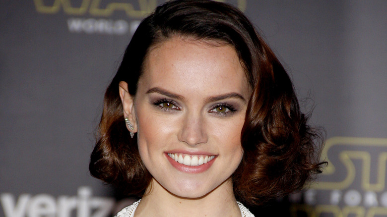 Daisy Ridley smiling with curled hair