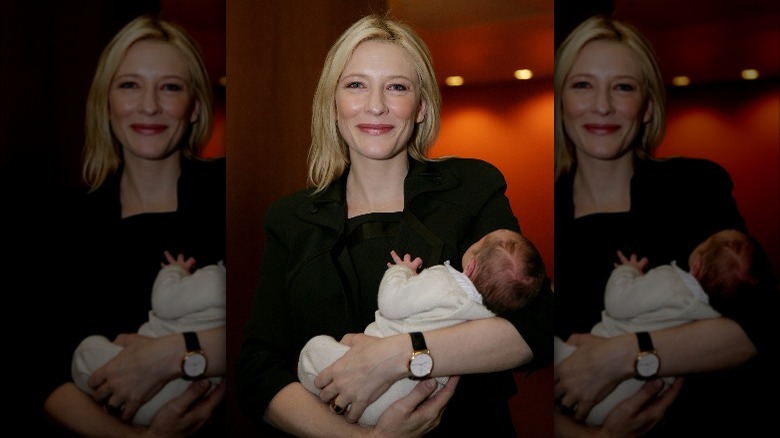 Cate Blanchett holding her infant son, smiling