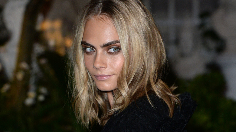 Cara Delevingne looking behind smiling 