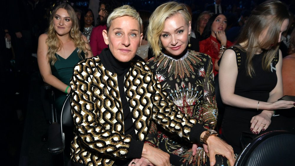 Ellen DeGeneres and Portia de Rossi posing while sitting at an awards show