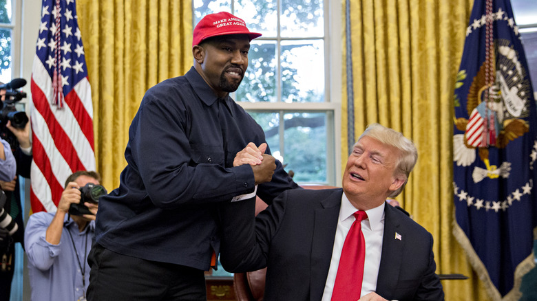 Kanye West shakes hands with former U.S. President Donald Trump during a meeting in the Oval Office of the White House in Washington, D.C.