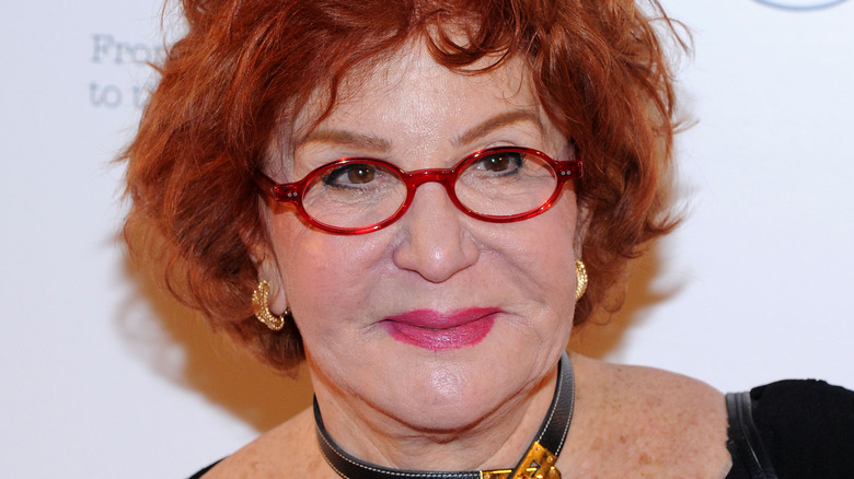 Sally Jessy Raphael poses in red-frame glasses