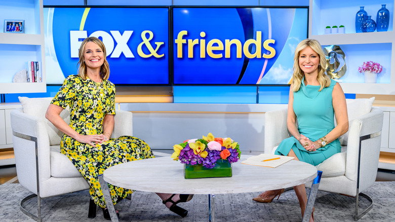 Ainsley Earhardt sitting with Savannah Guthrie on the Fox & Friends set