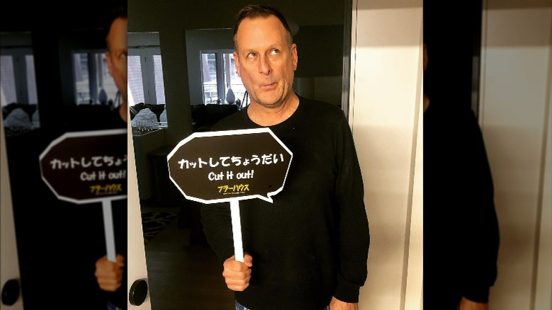 Dave Coulier holding "Cut It Out" sign