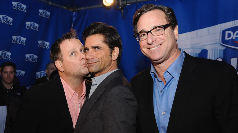 Dave Coulier kissing John Stamos, Bob Saget smiling