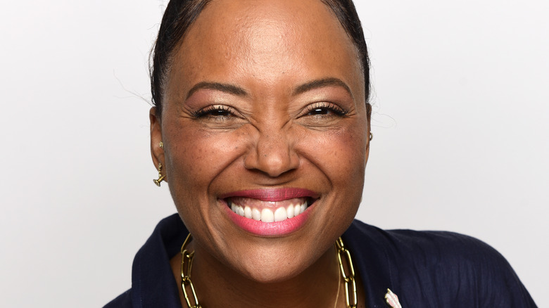 Aisha Tyler with a wide smile