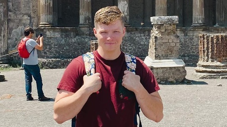 Garrison Brown smiling with backpack in front of columns