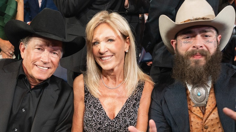 George Strait, Norma Strait, and Post Malone smile in the front row at the 2024 CMAs in Nashville, TN