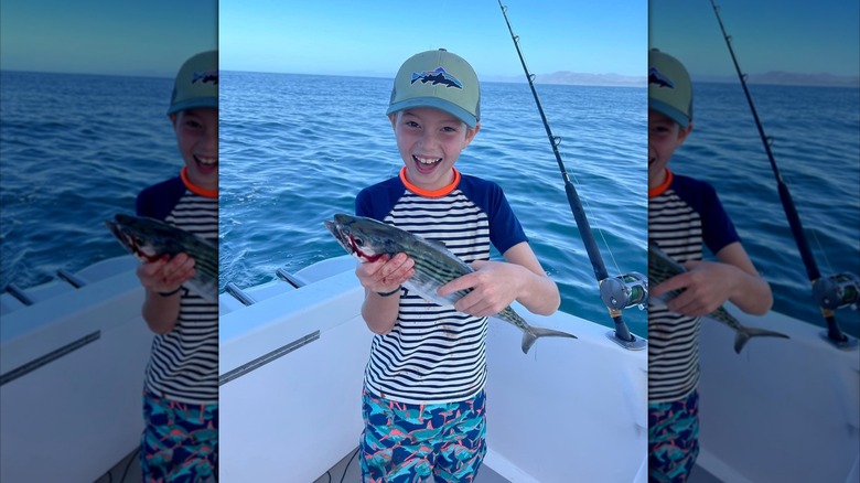 Joseph Frederick Kushner smiling and holding a fish on a boat