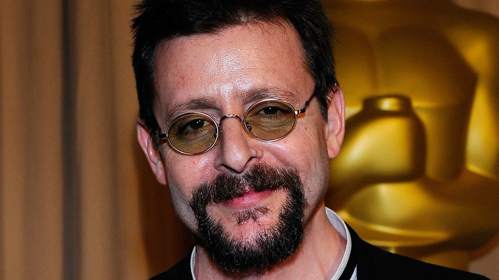 Judd Nelson smiling in front of Oscars statue