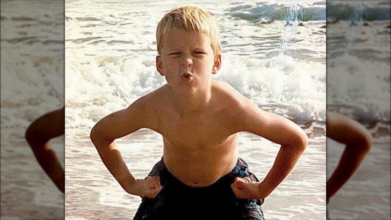 Glen Powell as a kid goofing around at the beach