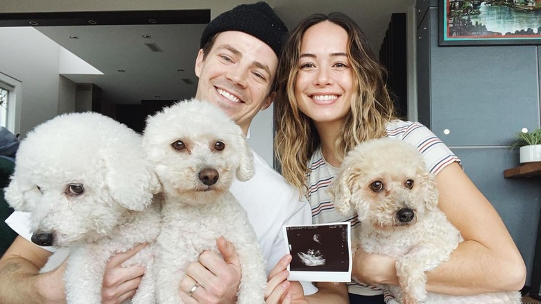 Grant Gustin smiling with wife and dogs