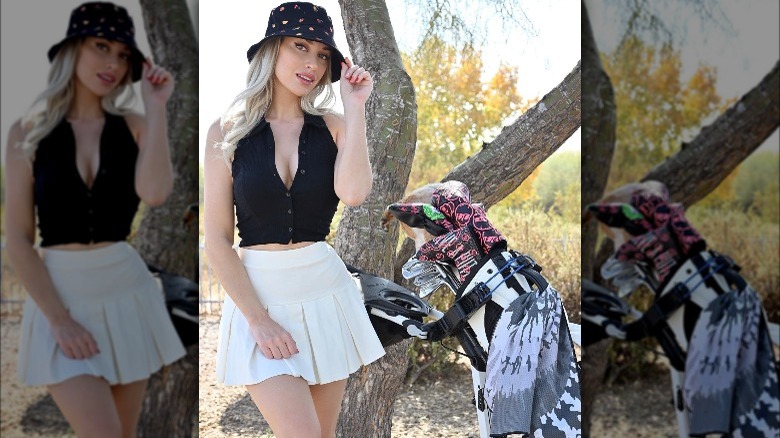 Paige Spiranac posing with golf clubs