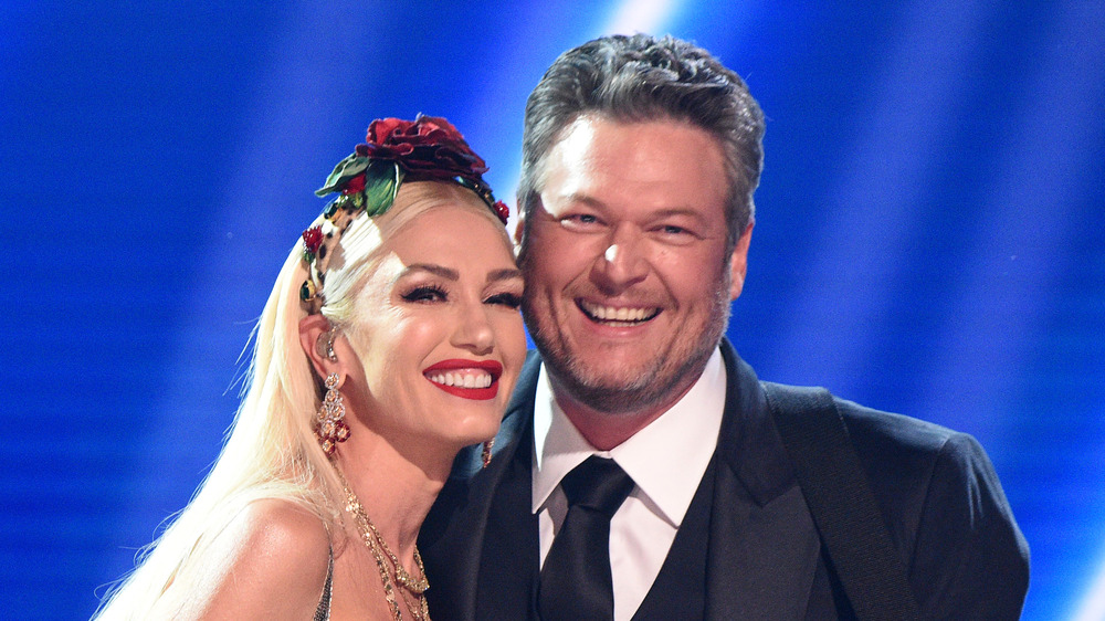 Gwen Stefani and Blake Shelton smiling on stage