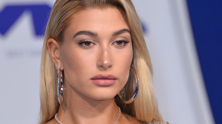 Hailey Bieber poses in silver hoop earrings