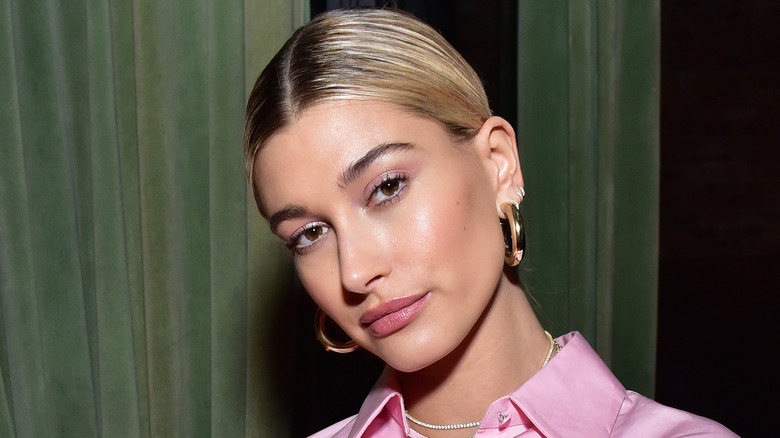 Hailey Bieber wearing a necklace and posing