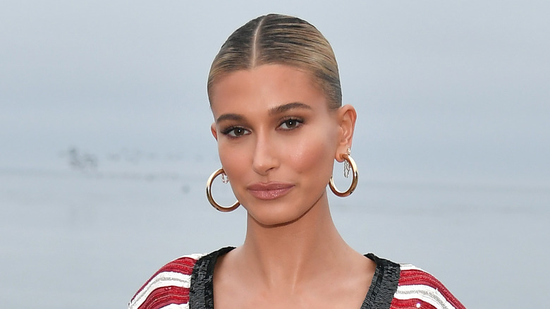 Hailey Bieber with a bun, posing