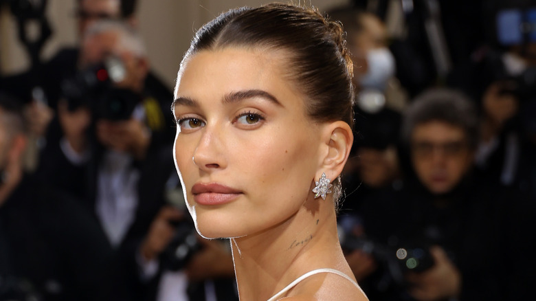 Hailey Bieber wearing earrings, posing