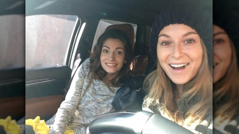 Alexa PenaVega taking a selfie with a friend in a car