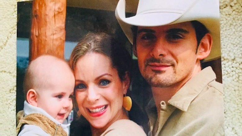 Kimberly Williams-Paisley and Brad Paisley smiling with their baby daughter