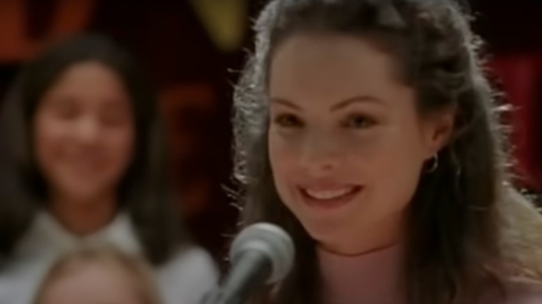 Kimberly Williams-Paisley smiling in front of a microphone in The Christmas Shoes