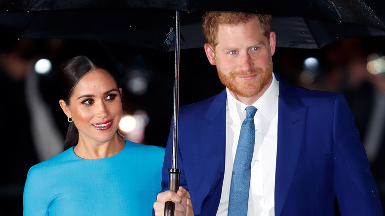 Meghan Markle and Prince Harry with an umbrella