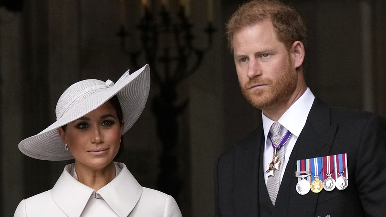 Prince Harry and Meghan Markle looking serious at an event 