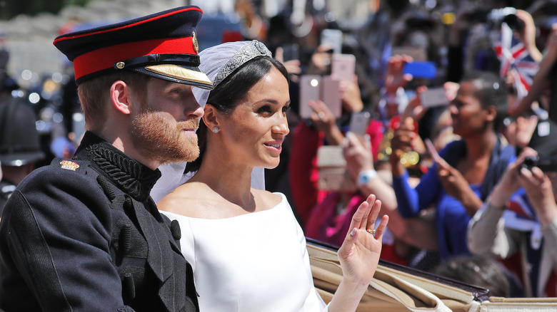 Prince Harry and Meghan Markle waving to crowds 