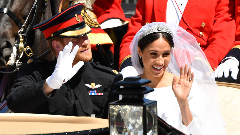 Prince Harry and Meghan Markle riding in a carriage