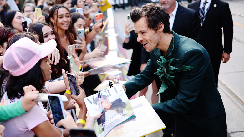 Harry Styles signing autographs