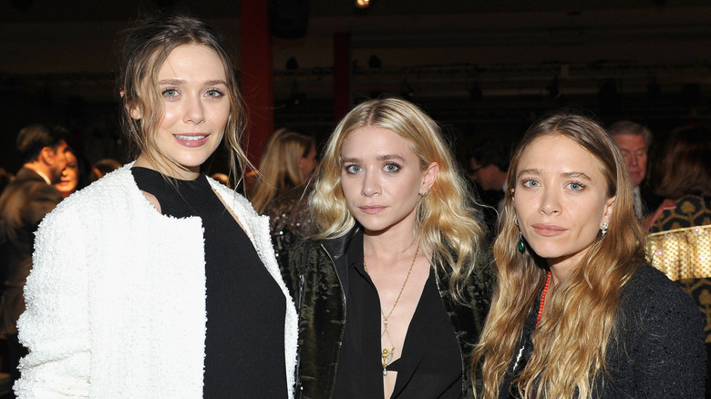 Elizabeth Olsen posing with sisters Mary-Kate and Ashley