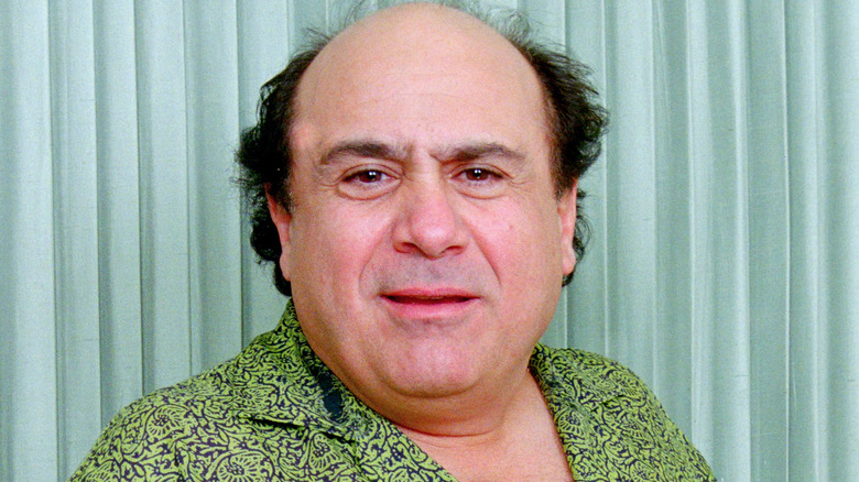 Danny DeVito squinting green shirt