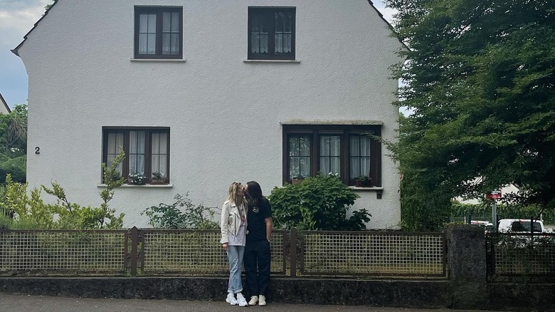 Heidi Klum and Tom Kaulitz  in front of a house