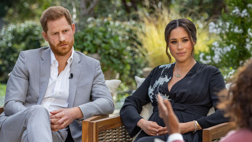 Prince Harry and Meghan Markle sitting in front of Oprah Winfrey