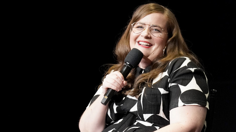 Aidy Bryant holding a microphone