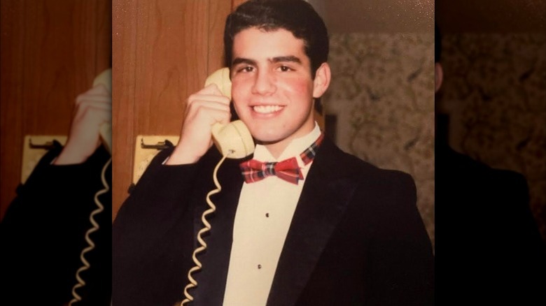 Young Andy Cohen holding a phone